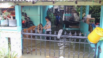 Warga beraktivitas di tengah banjir yang terjadi di pemukiman, kawasan Cakung, Jakarta, Rabu (29/1/2025). [Suara.com/Alfian Winanto]