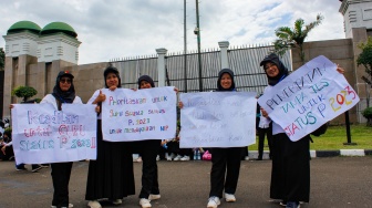 Massa aksi dari Forum Guru Swasta Nasional Passing Grade Tahun 2023 menggelar aksi demonstrasi di depan Gedung DPR, Jakarta, Kamis (30/1/2025). [Suara.com/Alfian Winanto]