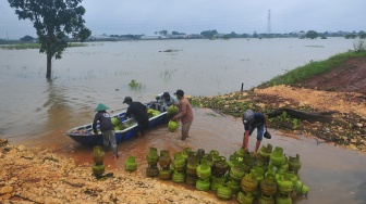 Warga mengangkut tabung gas elpiji dengan perahu untuk melintasi jalan yang tergenang banjir di Dukuh Karangturi, Desa Setrokalangan, Kaliwungu, Kudus, Jawa Tengah, Jumat (31/1/2025). [ANTARA FOTO/Yusuf Nugroho/foc]