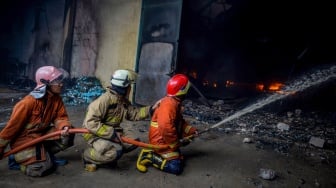 Petugas pemadam kebakaran menyemprotkan air ke arah api yang membakar salah satu gudang di kawasan pergudangan Pantai Indah Dadap, Kosambi, Kabupaten Tangerang, Banten, Jumat (31/1/2025). [ANTARA FOTO/Putra M. Akbar/app/nym]