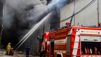 Petugas pemadam kebakaran menyemprotkan air ke arah api yang membakar salah satu gudang di kawasan pergudangan Pantai Indah Dadap, Kosambi, Kabupaten Tangerang, Banten, Jumat (31/1/2025). [ANTARA FOTO/Putra M. Akbar/app/nym]