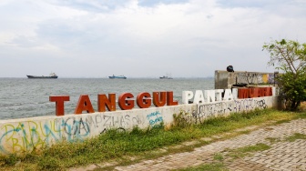 Warga beraktivitas di sekitar tanggul laut kawasan muara baru, Jakarta, Rabu (5/2/2025). [Suara.com/Alfian Winanto]