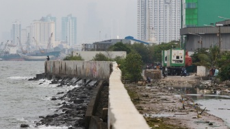 Warga beraktivitas di sekitar tanggul laut kawasan muara baru, Jakarta, Rabu (5/2/2025). [Suara.com/Alfian Winanto]