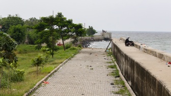 Warga beraktivitas di sekitar tanggul laut kawasan muara baru, Jakarta, Rabu (5/2/2025). [Suara.com/Alfian Winanto]