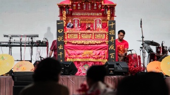 Warga melihat pertunjukan wayang potehi di kawasan Sudirman Central Business District (SCBD), Jakarta, Sabtu (8/2/2025). [Suara.com/Alfian Winanto]