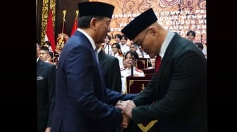 Menteri Pertahanan Sjafrie Sjamsoeddin (kiri) bersalaman dengan Deddy Corbuzier (kanan) saat Upacara Pelantikan Staf Khusus Menhan dan Asisten Khusus Menhan di Aula Bhineka Tunggal Ika Kementerian Pertahanan, Jakarta, Selasa (11/2/2025). [Instagram/dc.kemhan]