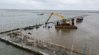 Operator alat berat escavator dari PT TRPN membongkar pagar laut dengan pengawasan Polisi Khusus Pengelolaan Pesisir dan Pulau-pulau kecil (Polsus PWP3K) Ditjen PSDKP di pesisir laut Tarumajaya, Kabupaten Bekasi, Jawa Barat, Selasa (11/2/2025). [ANTARA FOTO/Fakhri Hermansyah/rwa]