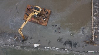 Foto udara alat berat escavator digunakan untuk membongkar pagar laut di pesisir laut Tarumajaya, Kabupaten Bekasi, Jawa Barat, Selasa (11/2/2025). [ANTARA FOTO/Fakhri Hermansyah/rwa]