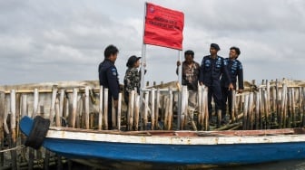 Personel Polisi Khusus Pengelolaan Pesisir dan Pulau-pulau kecil (Polsus PWP3K) Ditjen PSDKP memasang spanduk penghentian kegiatan pemagaran laut di pesisir Tarumajaya, Kabupaten Bekasi, Jawa Barat, Selasa (11/2/2025). [ANTARA FOTO/Fakhri Hermansyah/rwa]