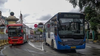 Bus Transjakarta melintas di Terminal Blok M, Jakarta, Rabu (12/2/2025). [Suara.com/Alfian Winanto]