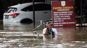 Warga membawa barang dari rumahnya yang terendam banjir di Kelurahan Manggala, Makassar, Sulawesi Selatan, Rabu (12/2/2025). [ANTARA FOTO/Arnas Padda/foc]