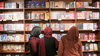 Pengunjung membaca buku di Makarya, toko buku Gramedia Matraman, Jakarta, Jumat  (14/02/2025). [Suara.com/Alfian Winanto]