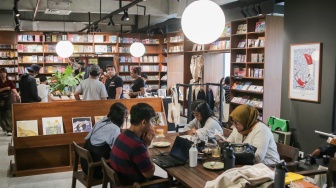 Pengunjung membaca buku di Makarya, toko buku Gramedia Matraman, Jakarta, Jumat  (14/02/2025). [Suara.com/Alfian Winanto]