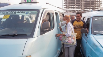 Sopir angkutan kota menunggu penumpang di Terminal Kampung Melayu, Jakarta, Jumat (14/2/2025). [Suara.com/Alfian Winanto]