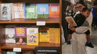 Pengunjung membaca buku di Makarya, toko buku Gramedia Matraman, Jakarta, Jumat  (14/02/2025). [Suara.com/Alfian Winanto]