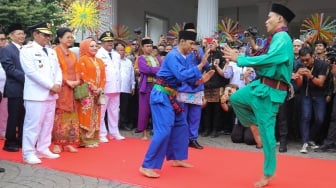 Gubernur dan Wakil Gubernur Jakarta Pramono Anung dan Rano Karno melihat kesenian palang pintu saat tiba di Balai Kota untuk melakukan Serah Terima Jabatan di Jakarta, Kamis (20/2/2025). [Suara.com/Alfian Winanto]