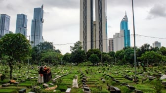 Warga melakukan ziarah kubur di TPU Karet Bivak, Jakarta, Sabtu (22/2/2025). [Suara.com/Alfian Winanto]
