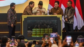 Presiden Prabowo Subianto (tengah) didampingi Menteri Koordinator Bidang Perekonomian Airlangga Hartarto (kedua kiri), Menteri BUMN Erick Thohir (kedua kanan), Dirut Pegadaian Damar Latri Setiawan (kanan), dan Dirut Bank Syariah Indonesia Hery Gunardi (kiri) memasukkan emas batangan saat meresmikan Layanan Bank Emas Pengadaian dan Bank Syariah Indonesia di The Gade Tower, Jakarta, Rabu (26/2/2025). [ANTARA FOTO/Muhammad Adimaja/tom]