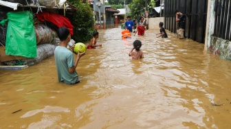 Warga beraktivitas di tengah banjir yang melanda di kawasan Tanjung Sanyang, Cawang, Jakarta, Senin (3/3/2025). [Suara.com/Alfian Winanto]
