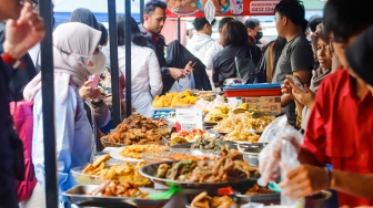 Warga berdesakan untuk membeli makanan yang dijual di Bazar Takjil, Bendungan Hilir, Jakarta, Senin (3/3/2025). [Suara.com/Alfian Winanto]
