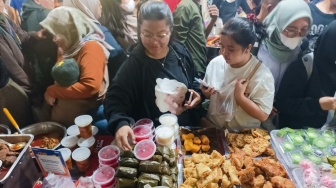 Warga berdesakan untuk membeli makanan yang dijual di Bazar Takjil, Bendungan Hilir, Jakarta, Senin (3/3/2025). [Suara.com/Alfian Winanto]