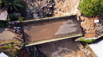 Foto udara kondisi jembatan Ciliwung yang putus akibat meluapnya sungai Ciliwung di Desa Jogjogan, Cisarua, Kabupaten Bogor, Jawa Barat, Senin (3/3/2025). [ANTARA FOTO/Yulius Satria Wijaya/YU]