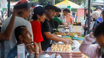 Warga berdesakan untuk membeli makanan yang dijual di Bazar Takjil, Bendungan Hilir, Jakarta, Senin (3/3/2025). [Suara.com/Alfian Winanto]
