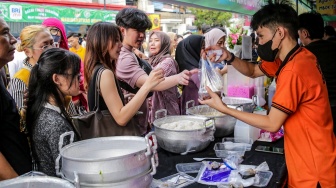 Warga berdesakan untuk membeli makanan yang dijual di Bazar Takjil, Bendungan Hilir, Jakarta, Senin (3/3/2025). [Suara.com/Alfian Winanto]