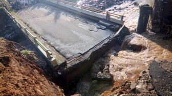 Warga melihat kondisi jembatan Ciliwung yang putus akibat meluapnya sungai Ciliwung di Desa Jogjogan, Cisarua, Kabupaten Bogor, Jawa Barat, Senin (3/3/2025). [ANTARA FOTO/Yulius Satria Wijaya/YU]