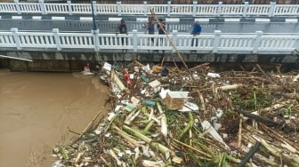 Kondisi jembatan yang dipenuhi sampah kiriman di kawasan perumahan Kemang Pratama, Bekasi, Jawa Barat, Selasa (4/3/2025). [Suara.com/Alfian Winanto]