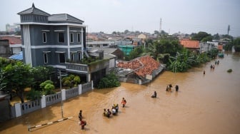 Warga melintasi banjir di kawasan Cililitan, Jakarta, Selasa (4/3/2025). [ANTARA FOTO/Akbar Nugroho Gumay/agr]