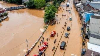 Foto udara sejumlah mobil melintasi banjir akibat luapan air Sungai Ciliwung di Jatinegara, Jakarta, Selasa (4/3/2025). [ANTARA FOTO/Bayu Pratama S/tom]