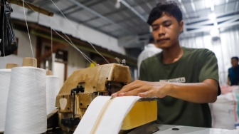 Pekerja menjahit bahan untuk dijadikan mukena di Pondok Aren, Tangerang Selatan, Rabu (5/3/2025). [Suara.com/Alfian Winanto]