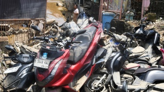 Warga mengamati motor yang terdampak banjir luapan Kali Bekasi di Sekolah Permata Sakti di Perumahan Pondok Gede Permai (PGP), Jatirasa, Bekasi, Jawa Barat, Rabu (5/3/2025). [ANTARA FOTO/Fakhri Hermansyah/foc]