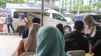 Warga menukarkan uang di Layanan Mobil Kas Keliling Bank Indonesia di Kompleks Masjid Al-Azhar, Jakarta, Rabu (5/3/2025). [Suara.com/Alfian Winanto]