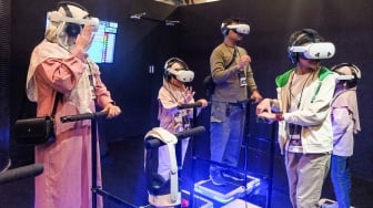 Pengunjung menggunakan perangkat virtual reality (VR) saat simulasi manasik haji di arena Manasik Xperience, Kuningan City, Jakarta, Senin (10/3/2025). [Suara.com/Alfian Winanto]