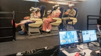 Pengunjung menggunakan perangkat virtual reality (VR) saat simulasi manasik haji di arena Manasik Xperience, Kuningan City, Jakarta, Senin (10/3/2025). [Suara.com/Alfian Winanto]