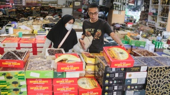 Pembeli memilih buah kurma di Pasar Tanah Abang, Jakarta, Rabu (12/3/2025). [Suara.com/Alfian Winanto]