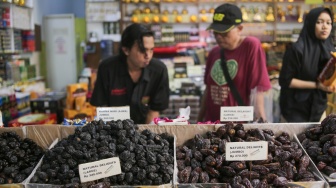 Pembeli memilih buah kurma di Pasar Tanah Abang, Jakarta, Rabu (12/3/2025). [Suara.com/Alfian Winanto]