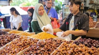 Pembeli memilih buah kurma di Pasar Tanah Abang, Jakarta, Rabu (12/3/2025). [Suara.com/Alfian Winanto]