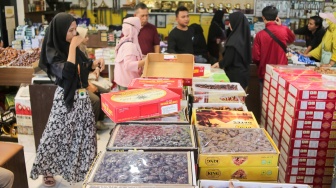 Pembeli memilih buah kurma di Pasar Tanah Abang, Jakarta, Rabu (12/3/2025). [Suara.com/Alfian Winanto]