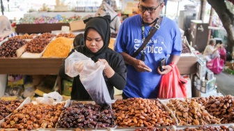 Pembeli memilih buah kurma di Pasar Tanah Abang, Jakarta, Rabu (12/3/2025). [Suara.com/Alfian Winanto]