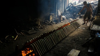 Pekerja menyelesaikan produksi lemang di kawasan Senen, Jakarta, Jumat (14/3/2025). [Suara.com/Alfian Winanto]
