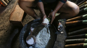 Pekerja menyelesaikan produksi lemang di kawasan Senen, Jakarta, Jumat (14/3/2025). [Suara.com/Alfian Winanto]
