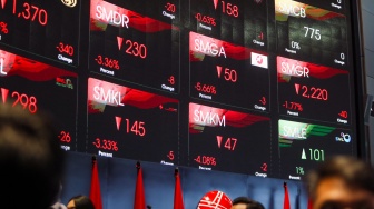 Pengunjung melintas dibawah layar pergerakan Indeks Harga Saham Gabungan (IHSG) di Bursa Efek Indonesia (BEI), Jakarta, Selasa (18/3/2025). [Suara.com/Alfian Winanto]