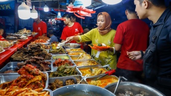 Pengunjung memilih menu berbuka puasa di Sentra kuliner Nasi Kapau di Jalan Kramat Raya, Senen, Jakarta, Selasa (18/3/2025). [Suara.com/Alfian Winanto]
