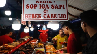 Pengunjung memilih menu berbuka puasa di Sentra kuliner Nasi Kapau di Jalan Kramat Raya, Senen, Jakarta, Selasa (18/3/2025). [Suara.com/Alfian Winanto]
