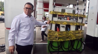 Menteri Perdagangan Budi Santoso (kiri) menunjukkan dispenser bensin Pertamina yang telah disegel di Jalan Alternatif Sentul, Kabupaten Bogor, Jawa Barat, Rabu (19/3/2025). [ANTARA FOTO/Yulius Satria Wijaya/tom]