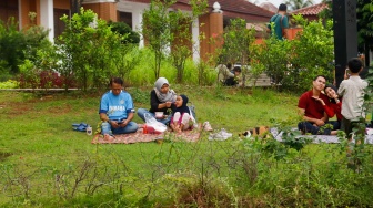 Warga beraktivitas menunggu waktu berbuka puasa di Taman Mini Indonesia Indah (TMII), Jakarta, Sabtu (22/3/2025). [Suara.com/Alfian Winanto]