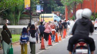 Warga beraktivitas menunggu waktu berbuka puasa di Taman Mini Indonesia Indah (TMII), Jakarta, Sabtu (22/3/2025). [Suara.com/Alfian Winanto]